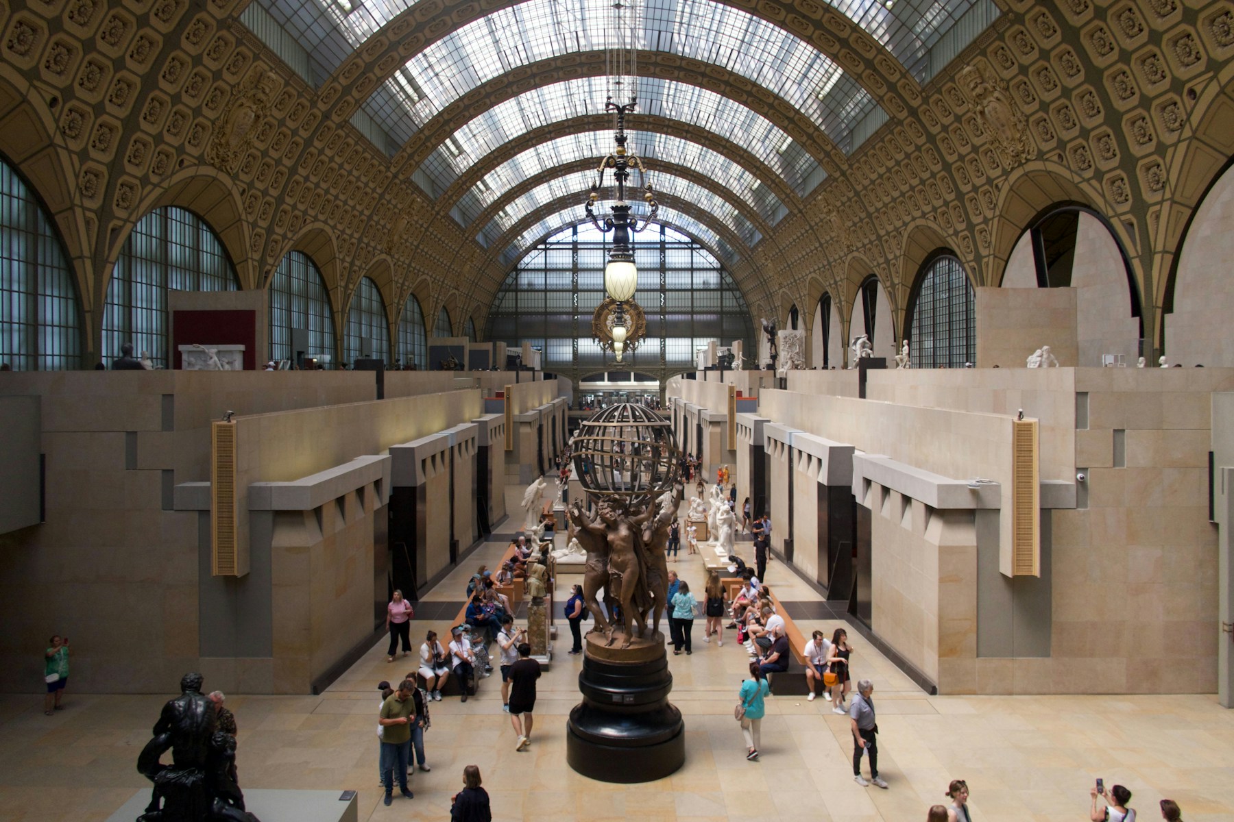 People walking through a grand museum hall with exhibits