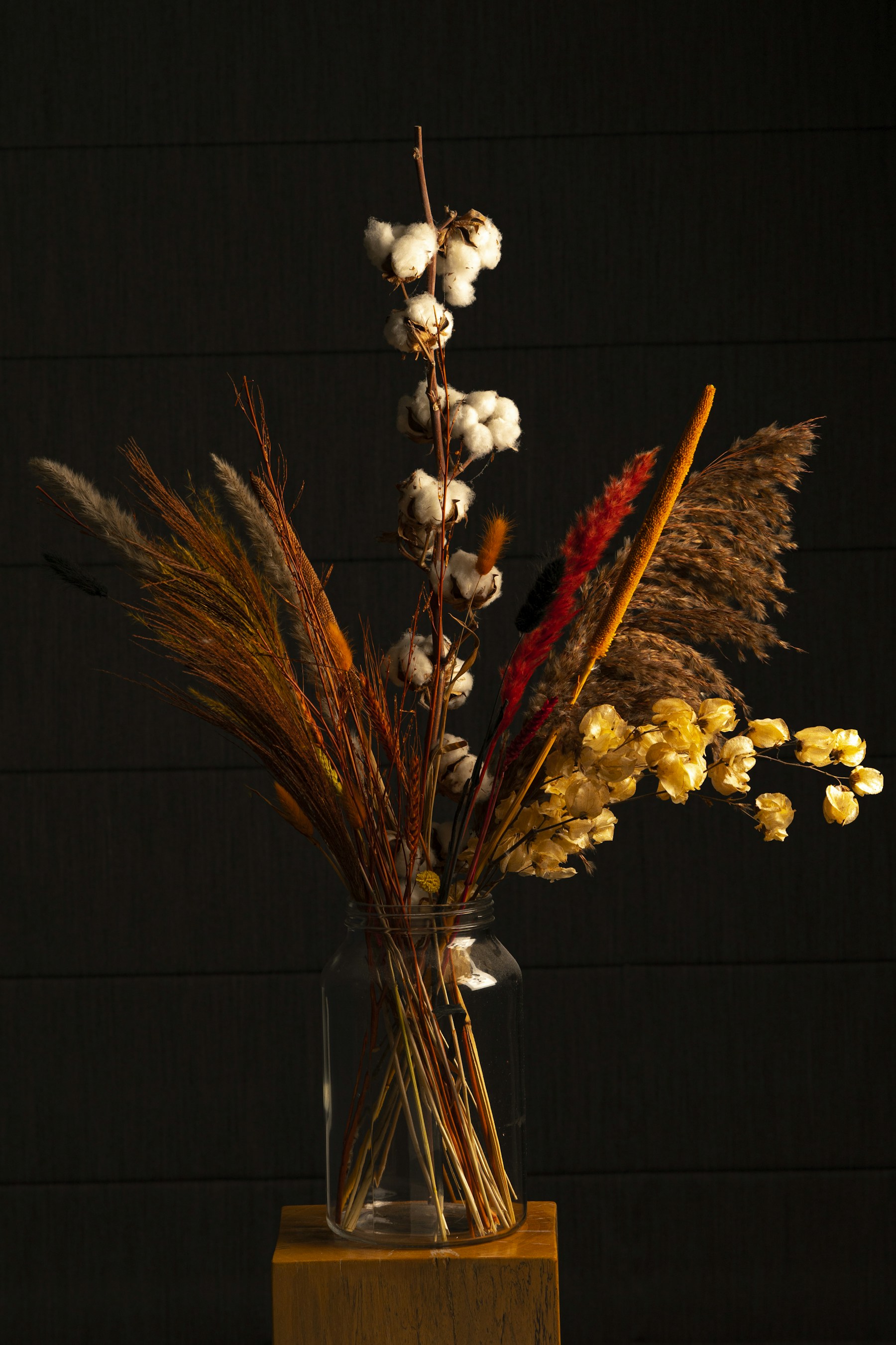 a vase filled with lots of dried flowers