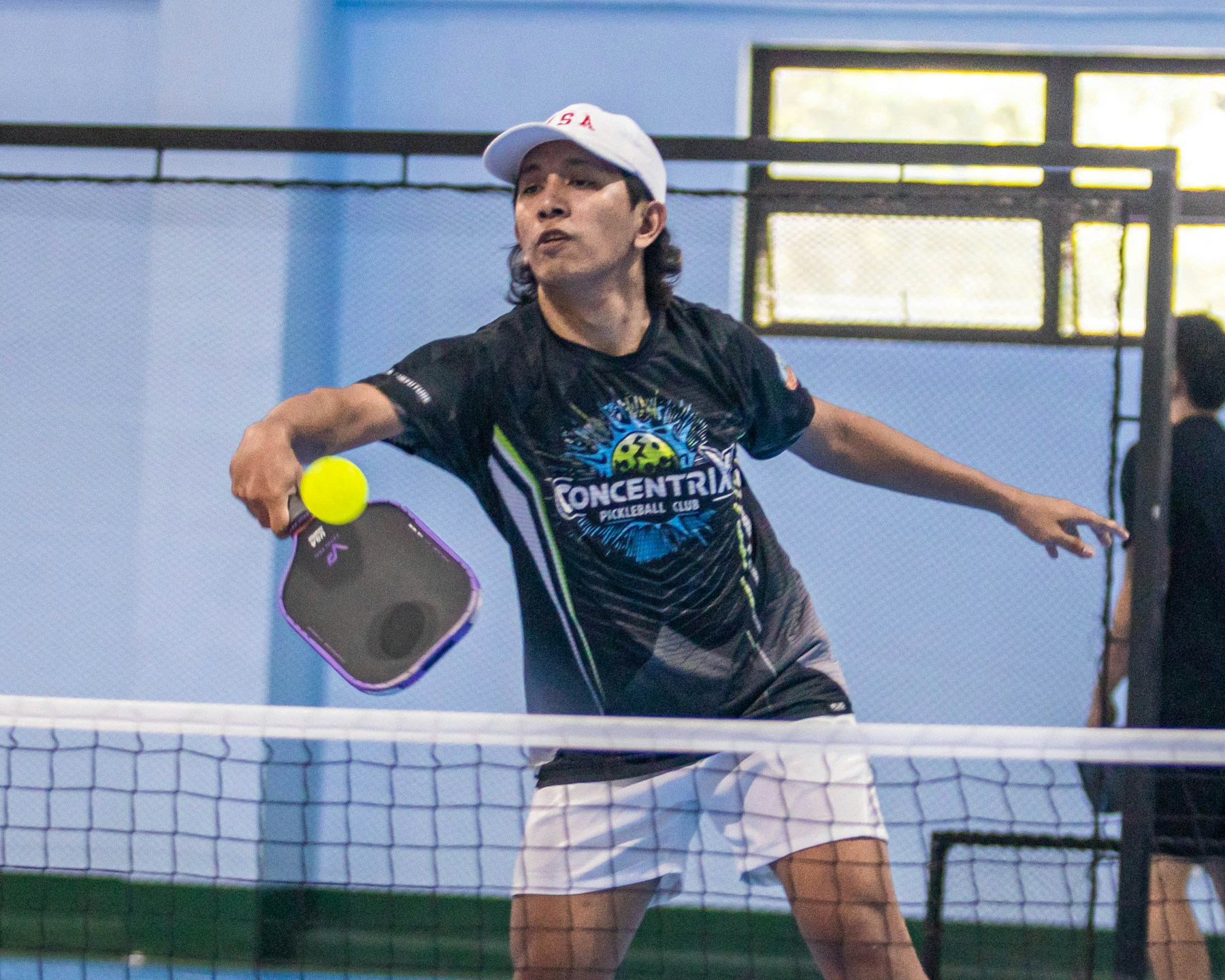 A man playing pickleball on an indoor court